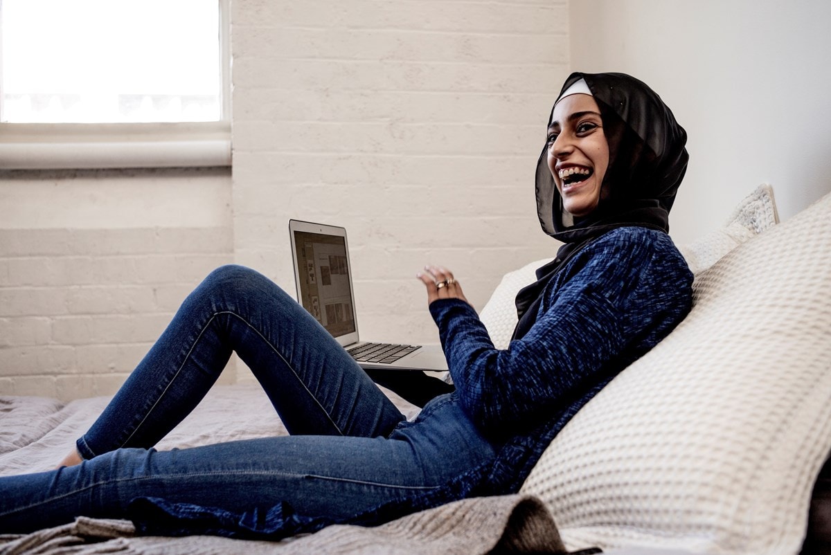 Woman working on laptiop and laughing