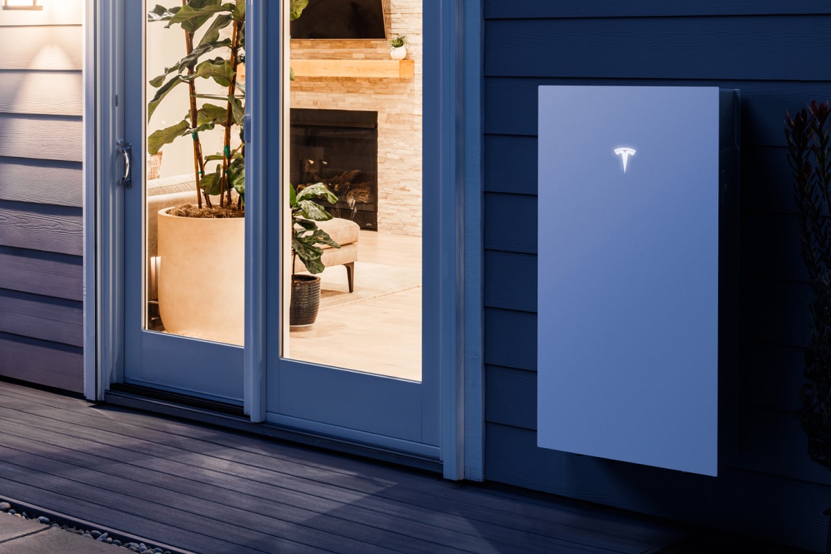 Tesla battery wall-mounted to the outside of a house.