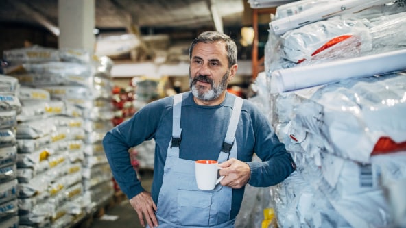 Man holding a mug standing next to stock
