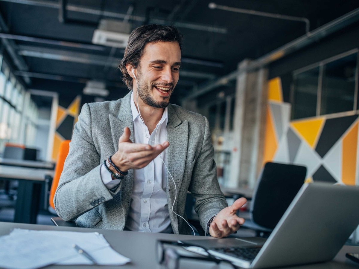 person talking in virtual office meeting through computer headphones